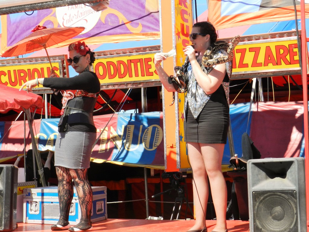Carnival ladies with snake wrapped around neck at the Tampa Florida State Fair. Keep reading to get the full 2024 Florida State Fair Guide with Tickets, Food, Concerts, Rides and More! Copyright ThemeParkHipster.