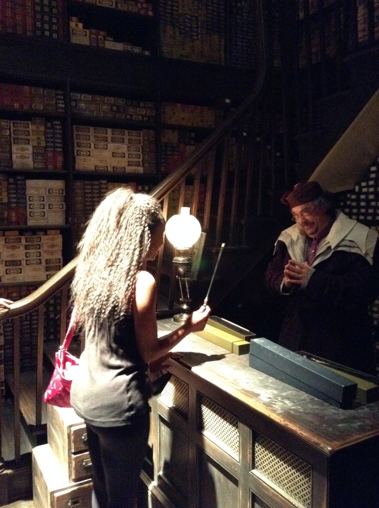 NikkyJ holding wand in Diagon Alley : Ollivander's Wand Shop in the Wizarding World of Harry Potter.
