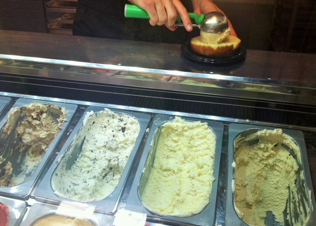 Step 1: Select a Flavor of Ice Cream at L’Artisan des Glaces. Lady putting ice cream on brioche bun. 