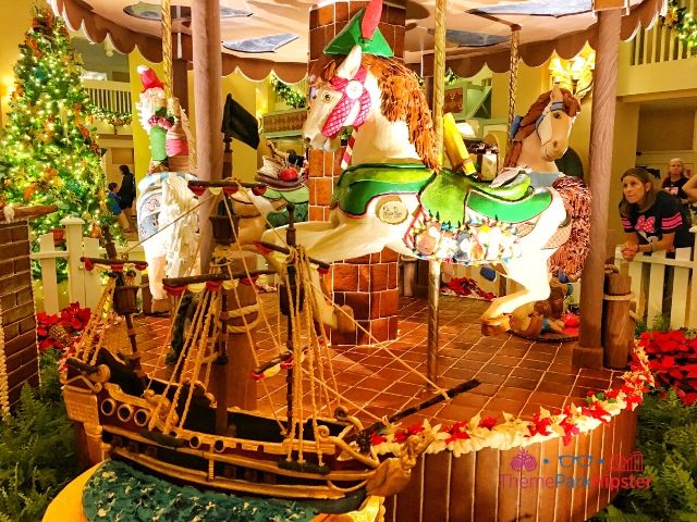 Disney Gingerbread House Carousel with Peter Pan horse and Captain Hook cake boat in front at Beach Club Resort. Keep reading to learn about the Disney World Gingerbread house display on Theme Park Hipster!