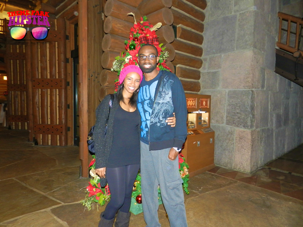 Merry Christmas from NikkyJ of ThemeParkHipster in front of Christmas Tree at Fort Wilderness Resort. Keep reading to learn about the best Disney Resorts at Christmas!