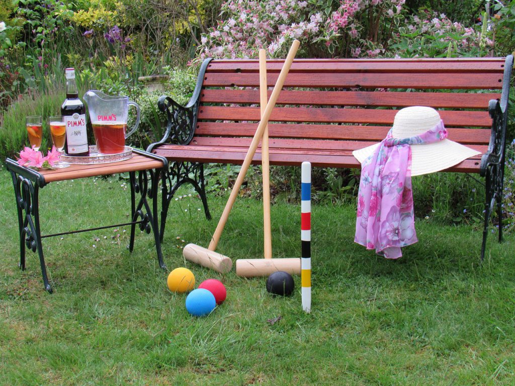 Pimm's cup next to croquet on bench