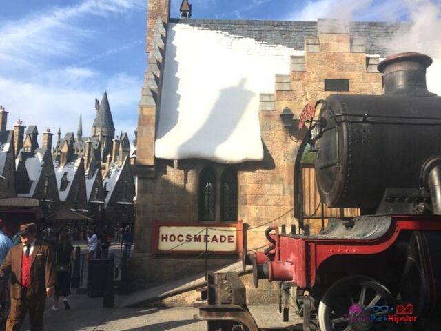 Hogsmeade at Universal with steam coming from engine and guests walking around.