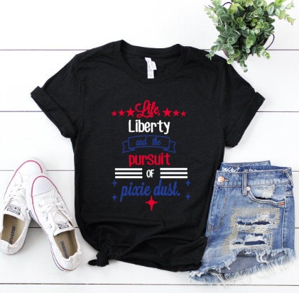 Pixie Dust Disney World fourth of july red, blue, and white words on blackshirt. Keep reading to know what to pack and what to wear to Disney World in July for your packing list.