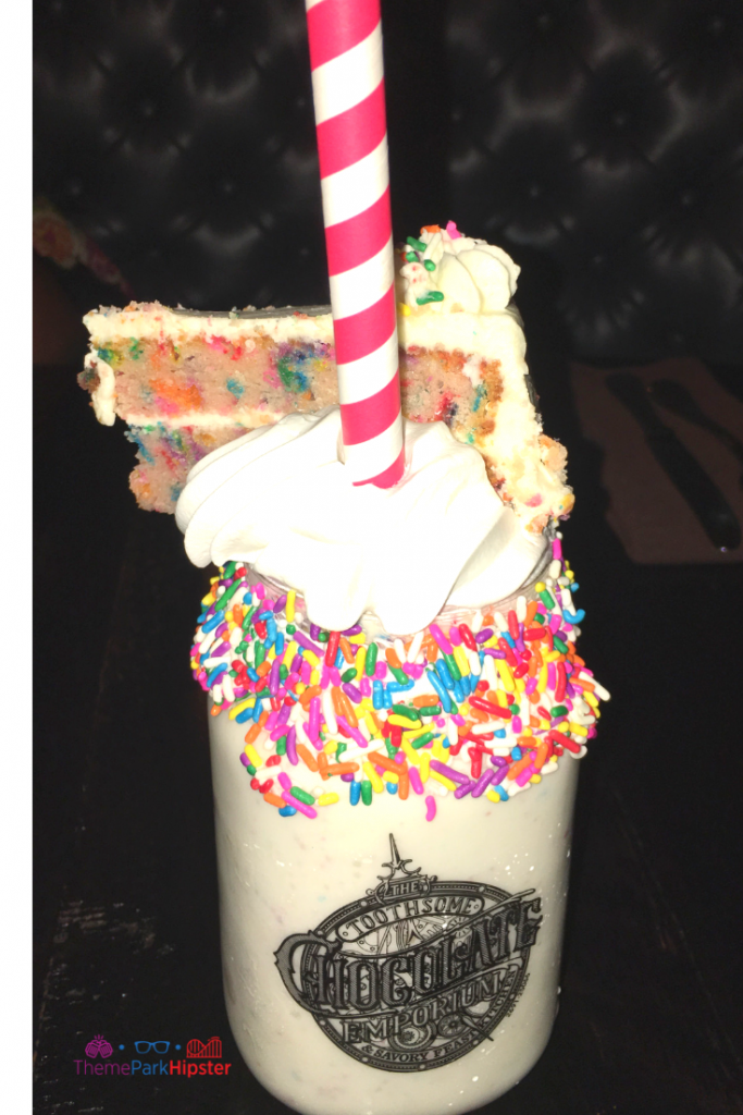 Toothsome Chocolate Emporium Milkshake with multi-color confetti cake on top. Keep reading to get the best Universal Studios Orlando tips for beginners and first timers.