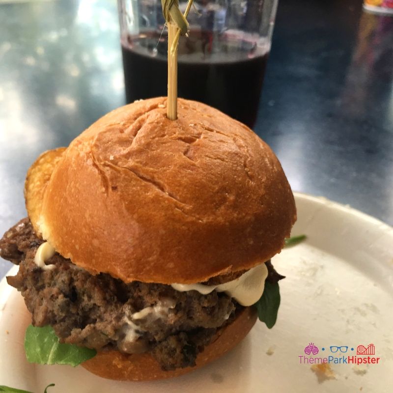 Steakhouse Blended Burger with blended beef and Mushroom Slider with brie cheese fondue, arugula, and a truffle and blue cheese potato chip on a brioche bun at Flavors from Fire Epcot. Keep reading to get the best things to do at Epcot Food and Wine Festival.