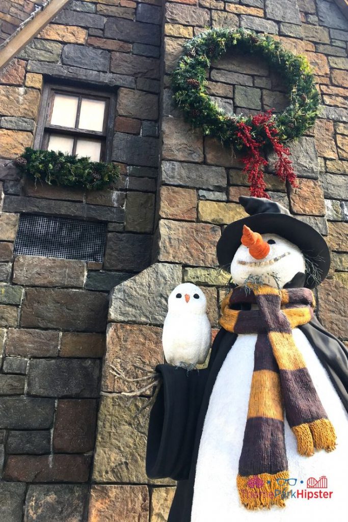 Christmas at Universal Harry Potter Christmas Snowman in front of castle. Keep reading to get the full guide to Christmas at Universal Orlando Resort!