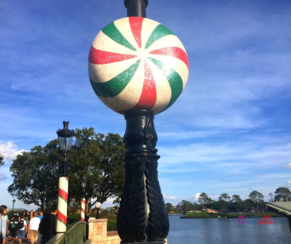 Epcot Festival of the Holidays France Pavilion with Green Red and White Peppermint Light Pole. Keep reading to learn about the best things to do at Disney World for Christmas 2023.