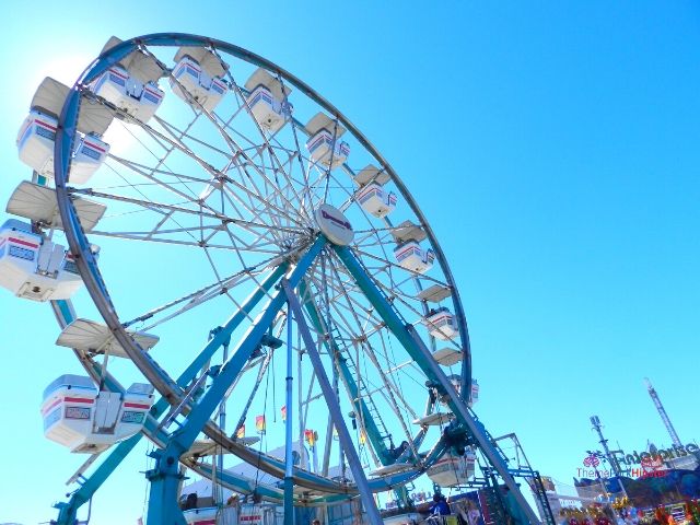 Florida State Fair Large White and Blue Ferris Wheel. Keep reading to get the full Florida State Fair Guide with Tickets, Food, Concerts, Rides and More!