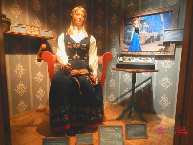 Norway Pavilion at Epcot Woman Sitting in Traditional Chair and Garb Next to Frozen Animation Image 