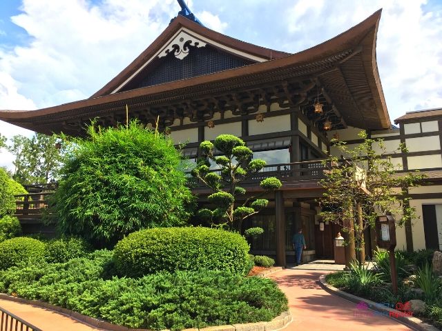The outside of Takumi Tei Japanese Restaurant, in Epcot, with a towering Japanese style building with manicured greenery in front. Keep reading to learn the 25 most romantic things to do at Disney World for couples. 