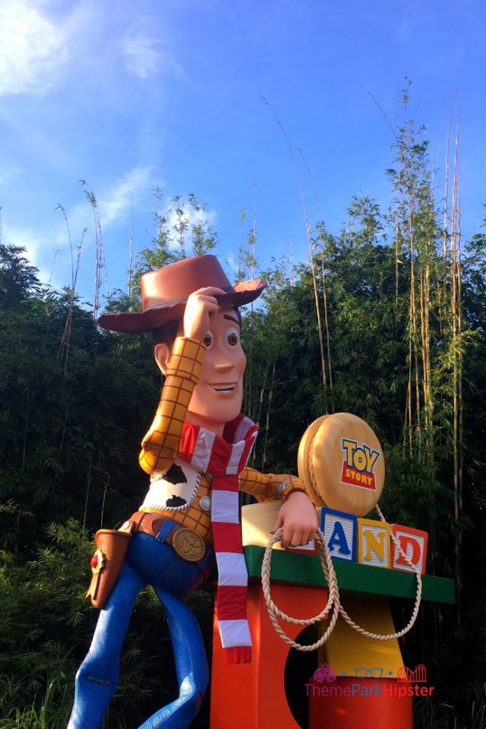 Christmas in Toy Story Land with Woody in Santa Scarf. Keep reading to get the best Disney Christmas pictures and to know where to take the best Christmas photos at Disney World!