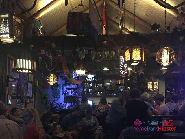 Trader Sam Grog Grotto Bar Area filled with tropical decor filled with guests relaxing at tables.  Keep reading to learn the 25 most romantic things to do at Disney World for couples. 