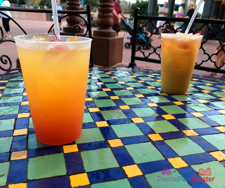 Spice Road Table at Epcot Mediterranean Journey Orange Cocktail on colorful table. Keep reading to learn how to do Disney World on a Budget for a solo trip.