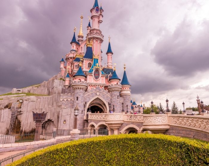 Solo Travel Tips for Theme Parks with Pink Sleeping Beauty Castle Disneyland Paris
