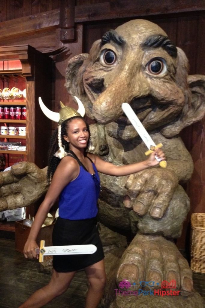 NikkyJ at Norway in front of troll. Keep reading to learn how to do Disney World on a Budget for a solo trip.