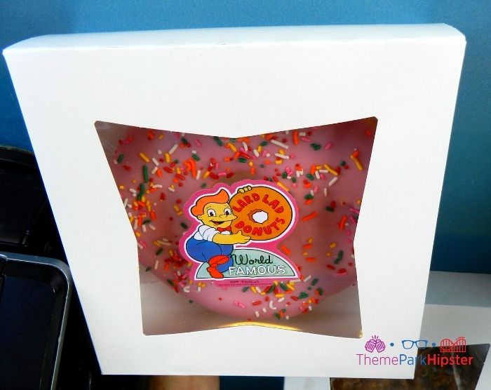 Big pink donut at Lard Lad Donuts in Universal Studios. Keep reading to learn about the cheap, best food at Universal Studios Orlando, Florida.
