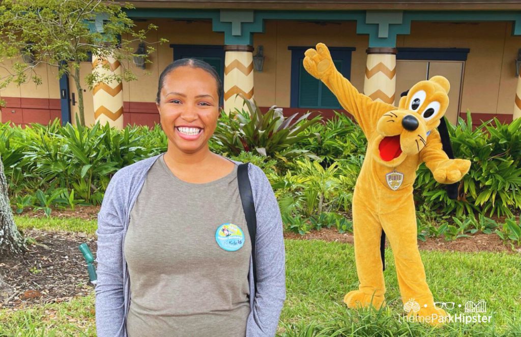NikkyJ and Pluto with her birthday pin at Coronado Springs Resort. One of the best things for adults to do at Disney World. Keep reading to find out more about the free dining plan at Disney World. 