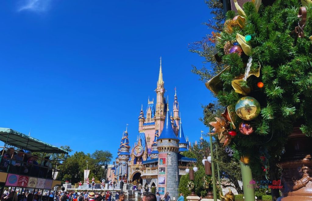 Cinderella Castle for 50th Anniversary Celebration with the Omnibus. Keep reading to learn more about surviving your Disney World Christmas trip and the Disney Christmas decorations.