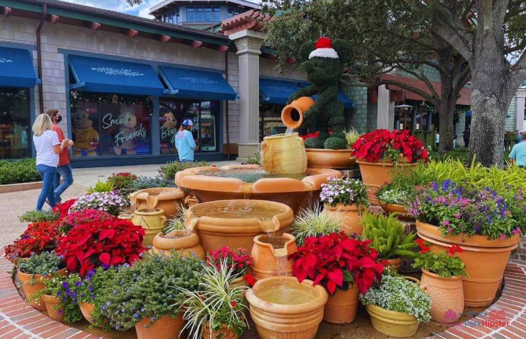 Mickey Mouse Fountain in Disney Springs with Christmas Decorations. Keep reading to get the best Disney Christmas pictures and to know where to take the best Christmas photos at Disney World!