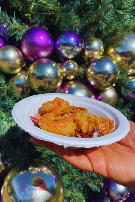 SeaWorld Christmas Celebration Fried Shrimp in front of Christmas Tree. Keep reading to learn about Christmas at SeaWorld Orlando!