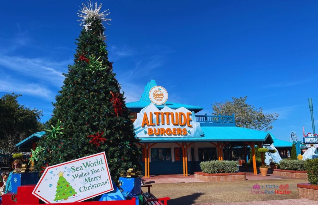 2023 SeaWorld Christmas Celebration Holiday Tree in Front of Altitude Burgers. Keep reading to learn about Christmas at SeaWorld Orlando!