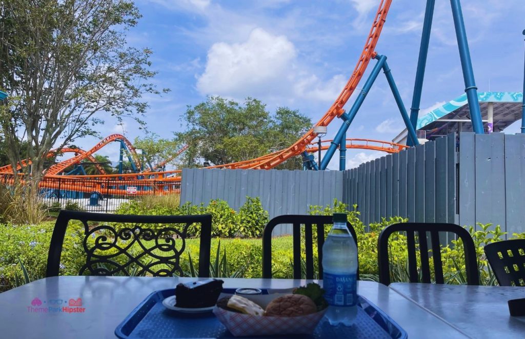 SeaWorld Orlando Altitude Burger food in front of Icebreaker roller coaster. Keep reading to learn if the SeaWorld All Day dining plan is worth it.