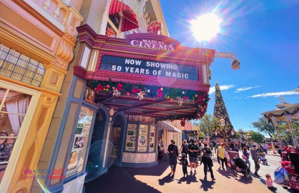 Disney Magic Kingdom Main Street Cinema with Christmas Tree in the Background. Keep reading to get the best things to do at the Magic Kingdom for Christmas and a full guide to 2023 Mickey's Very Merry Christmas Party Tips!