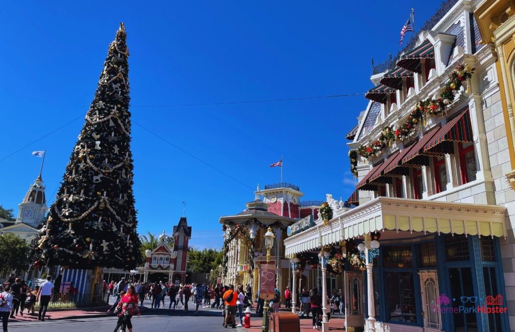 Disney Magic Kingdom Main Street USA with Christmas Tree. Keep reading to learn more about your Disney World Christmas trip and the Disney Christmas decorations.