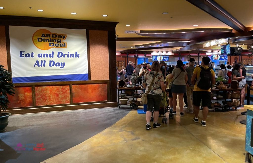 Busch Gardens Tampa Bay all day dining deal sign and theme park guests filling up the tables and food ordering area. Keep reading to learn more about what to eat at Busch Gardens Tampa.