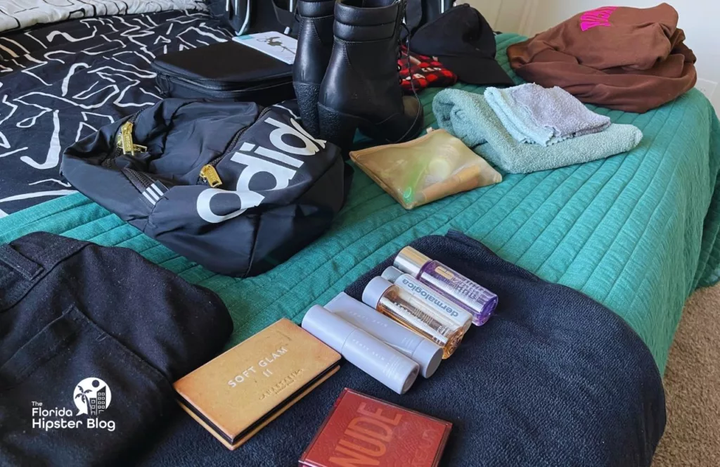 My clothes laid out on the bed for my theme park packing list featuring small back pack, light clothing and much more for my Universal Studios Trip.