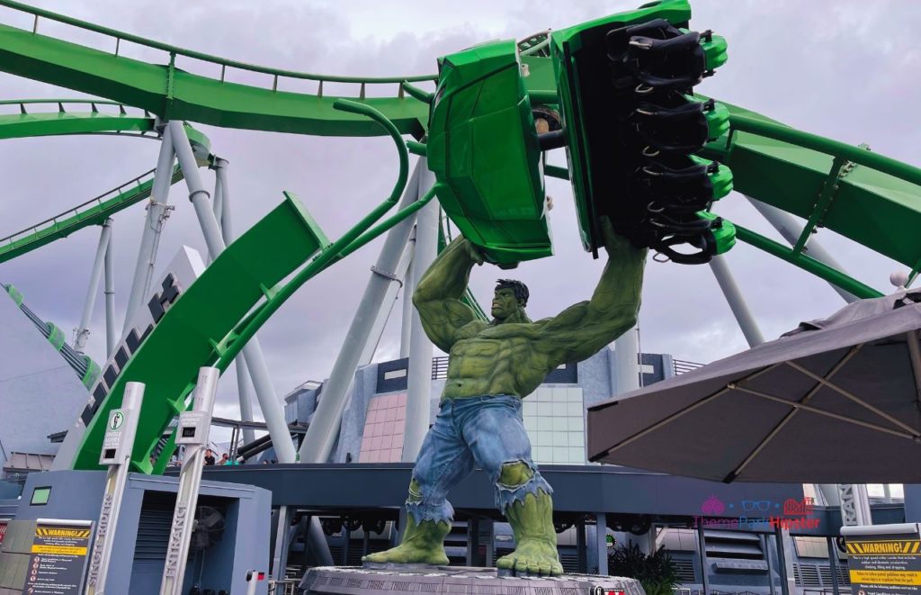 Universal Orlando Resort Incredible Hulk Roller Coaster at Islands of Adventure, with the hulk holding a train car over his head under the tracks of the coaster. Keep reading to discover more about Universal Orlando Coasters: Hulk vs VelociCoaster.