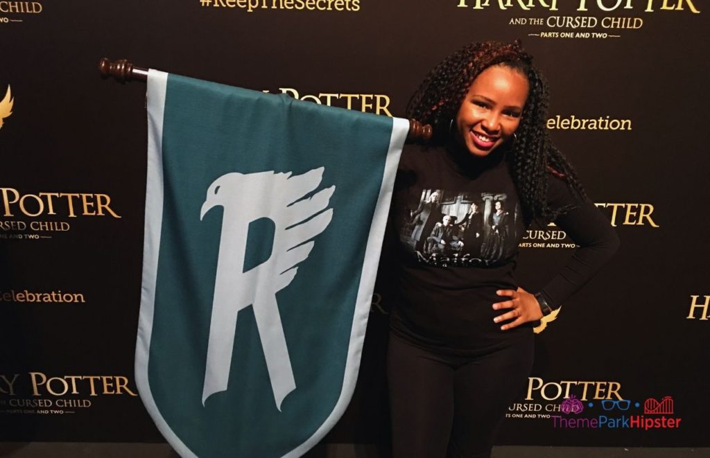 NikkyJ at Universal Orlando Resort with Ravenclaw Flag at a celebration of Harry Potter World. Keep reading if you want to learn more about what to wear to Universal Studios Florida.