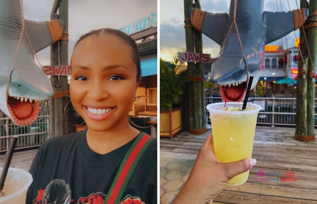 Universal Orlando Resort NikkyJ enjoying a margarita at Chez Alcatraz with Jaws Bruce the Shark in background at Universal Studios. Keep reading to know what to pack for an amusement park and have the best theme park packing list.