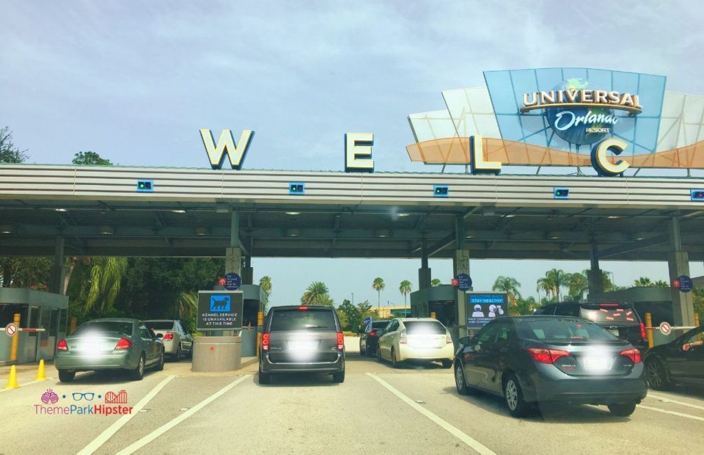 Universal Orlando Resort parking gate with welcome sign with several lines of cars entering to park. 