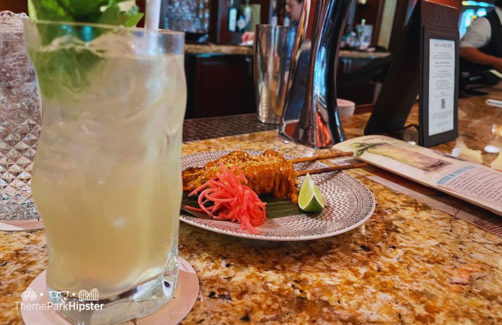 Nomad Lounge at Disney's Animal Kingdom Theme Park Grilled Chicken Satay and Snow Leopard Salvation Cocktail Drink. One of the Best Alcoholic Drinks and cocktails at Disney World.