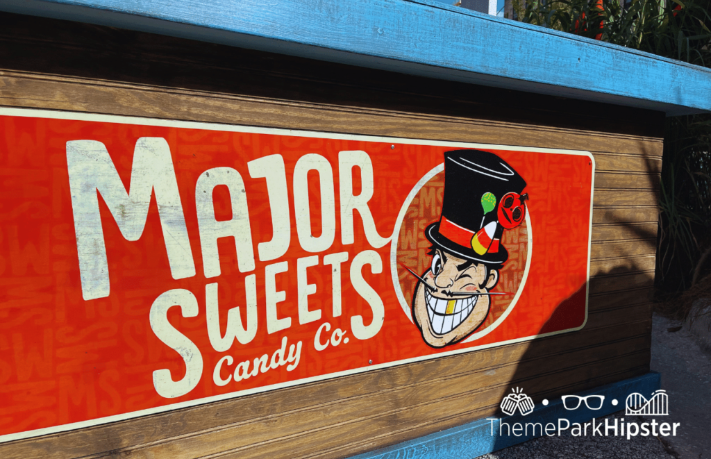 Major Sweets Candy CO. sign with Major Sweets wearing a top hat adorned with candy for Universal Studios HHN 31 Halloween Horror Nights 2022. Keep reading to learn more about Scare zones at Halloween Horror Nights.