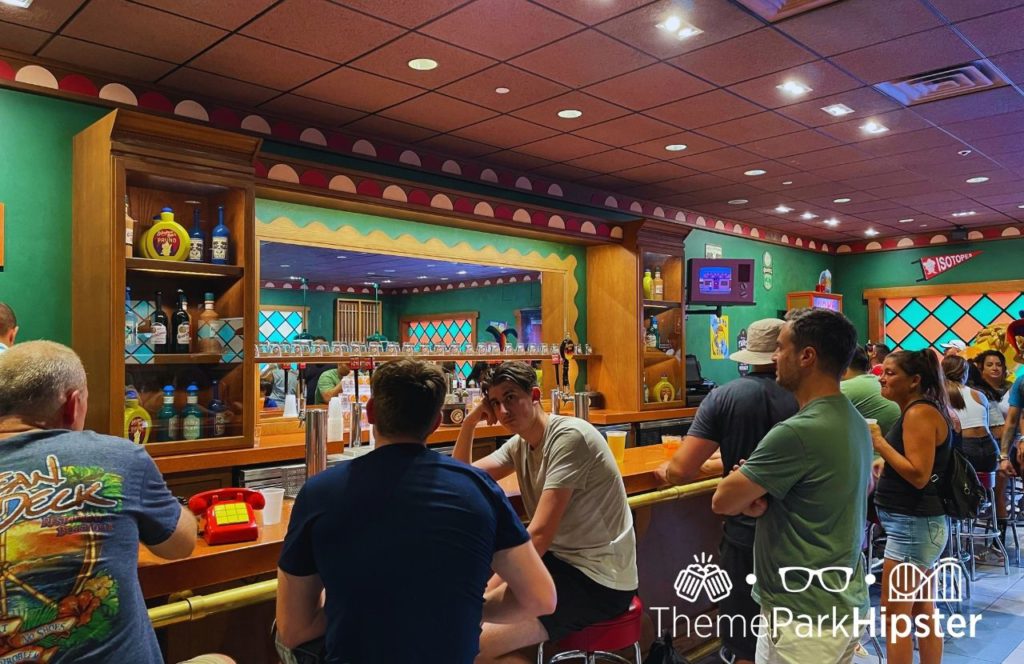 Universal Orlando Resort Moe's Tavern at Universal Studios Florida in Simpsons Land with men dressed in casual tees sitting around the bar area. Keep reading to discover what to pack for Universal Studios Florida.