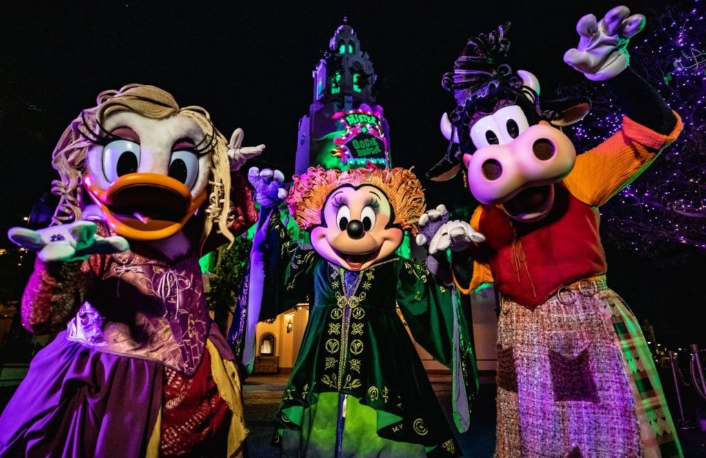 Minnie Mouse, Daisy Duck and Clarabelle Cow dressed as the Sanderson Sisters from Hocus Pocus during Halloween at Disneyland and Disney California Adventure Oogie Boogie Bash Party Food, Tips, Dates and more Disney Halloween Guide.