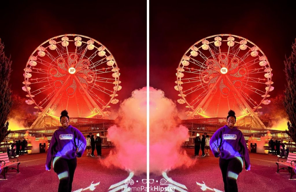 Victoria Wade in front of Ferris Wheel during Halloween at Hersheypark Dark Nights. Keep reading to get the full Hersheypark list of rides and attractions.