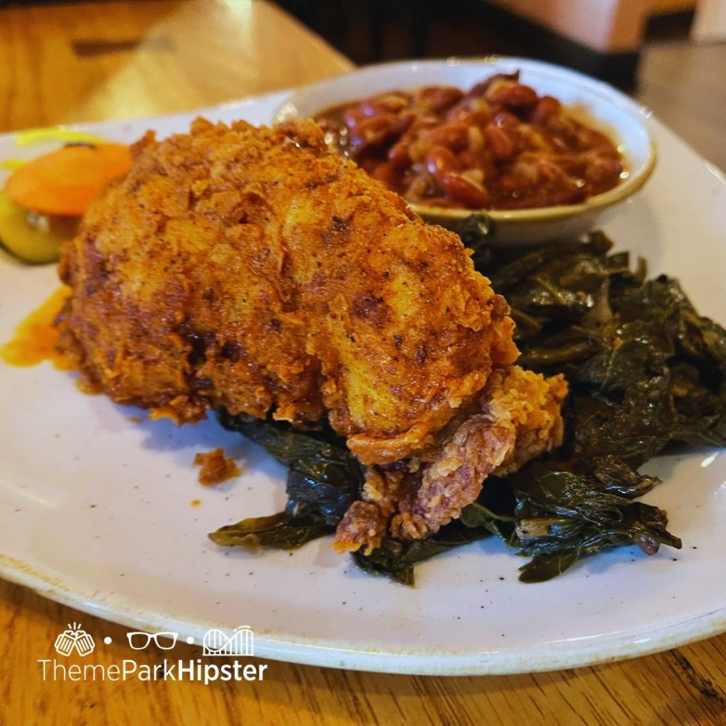 Boatwrights Dining Hall at Disney Port Orleans Resort Fried Nashville Chicken with Greens and Baked Beans. Keep reading to learn how to do Thanksgiving Day Dinner at Disney World.