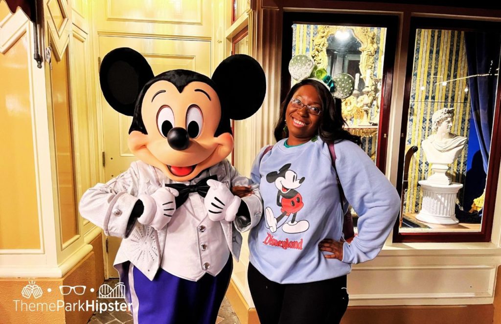Disneyland Resort Mickey Mouse in Disney 100 Anniversary Outfit next to Victoria Wade. Keep reading to learn what to wear to Disneyland in February and what to pack for your Disney trip!