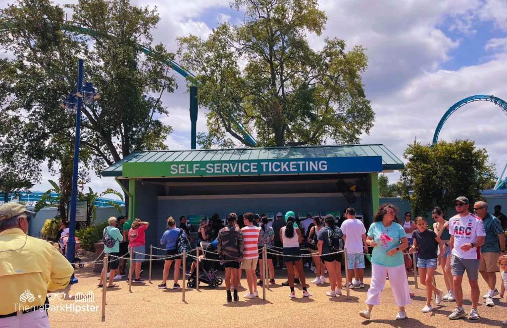 SeaWorld Orlando Resort Self Service ticketing kiosk with a line full of guests. Keep reading to discover more about Sharks Underwater Grill at SeaWorld Orlando.