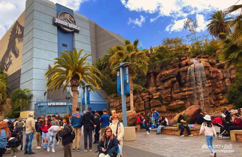 Universal Studios Hollywood Jurassic World with cascading waterfall over a rock cliff. Keep reading to find out more of the best Universal Studios Hollywood attractions for solo travelers.