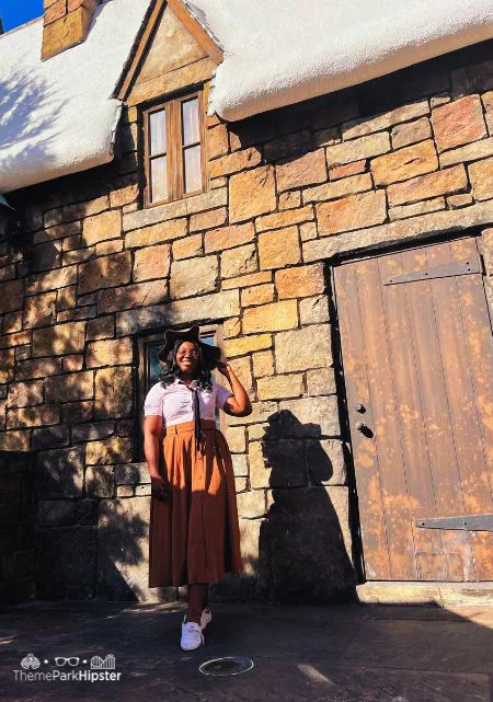 Best Spots for Wizarding World of Harry Potter Photos with Victoria Wade behind Three Broomsticks in Hogsmeade. Keep reading to get the best Harry Potter secrets at Universal Studios.