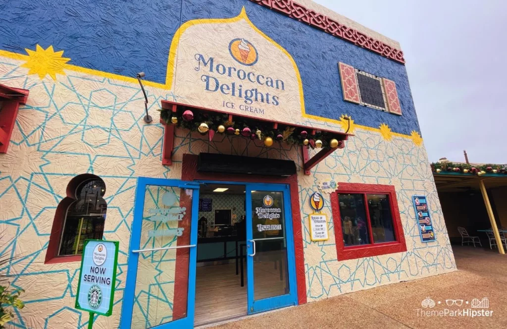 Moroccan Delights Ice Cream entrance with a white building and red and blue design and planters at  Busch Gardens Tampa Bay. Keep reading to discover more about restaurants at Busch Gardens Tampa.