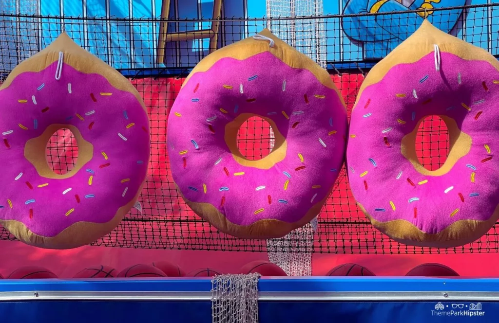 Universal Orlando Resort Big Pink Donut Toys in Simpsonland at Universal Studios Florida Carnival Games. Keep reading to get the best things to do at Universal Studios Florida.