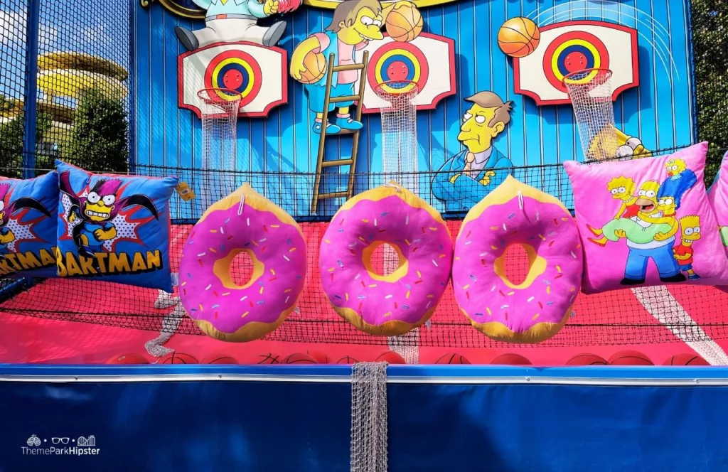 Universal Orlando Resort Big Pink Donut Toys in Simpsonland at Universal Studios Florida Carnival Games. Keep reading to get the best things to do at Universal Studios Orlando Florida.