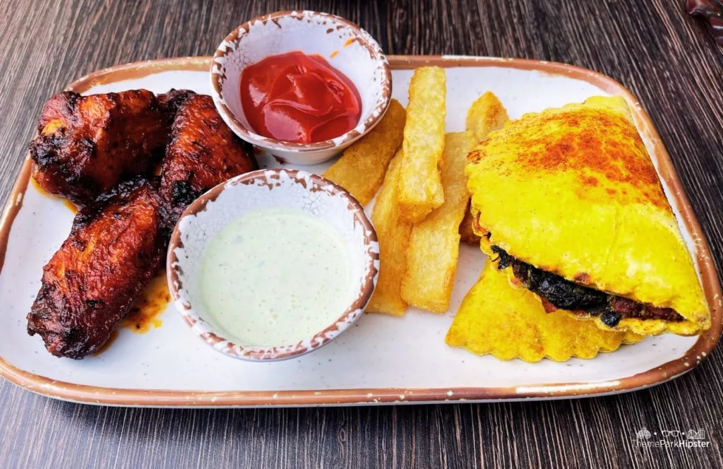 Universal Orlando Resort Bob Marley a Tribute to Freedom Restaurant in CityWalk Taste of Jamaica Jerk Wings Yuca Fries and Beef Patty. Keep reading to get the full Guide to Universal CityWalk Orlando with photos, restaurants, parking and more!