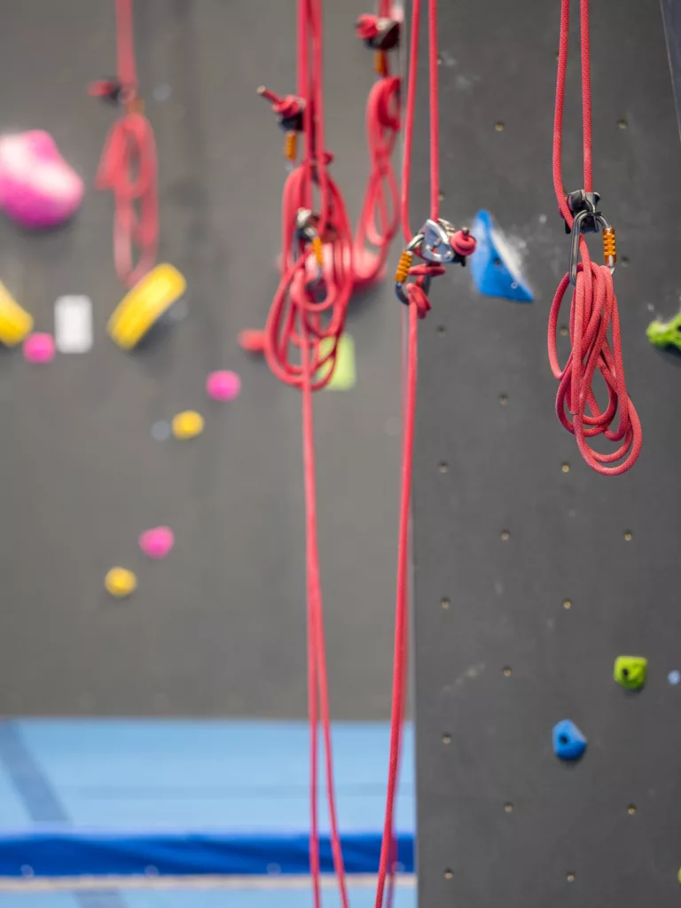 Indoor rock climbing wall with hanging red rope equipment. Keep reading to find out more of the best things to do at Cedar Point. 